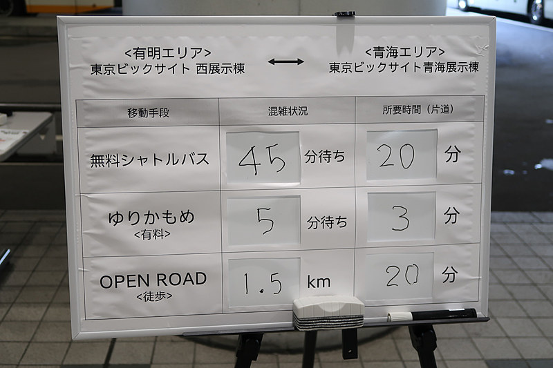 東京ビッグサイト1階の出口付近で無料シャトルバスなどの利用状況が紹介されていた。写真では45分待ちと書かれているが、スタッフの口頭で50分待ちが告げられていた