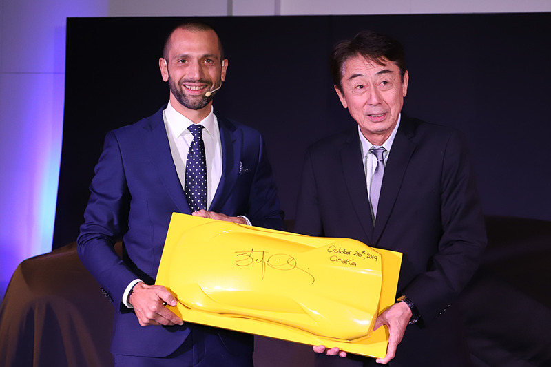 クレシ氏（左）が光岡氏（右）にプレゼントを手渡した