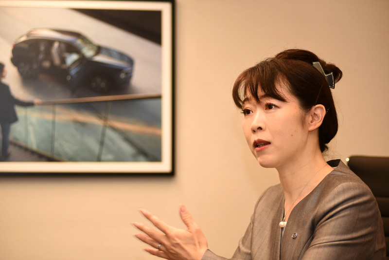 MX-30開発担当主査、竹内都美子さん。1997年にマツダに入社し、電子技術開発部でハーネス設計を担当。1999年にはR＆D技術管理本部で総合商品性能評価を担い、その後「プレマシー」や「RX-8」の評価を受け持つ。2009年より車両開発本部・車両開発推進部で新世代技術とプラットフォームの開発を担当。2011年から「MAZDA2/デミオ」の性能開発に関わり、2015年2月に商品本部の主査に着任。以降、MX-30の主査として開発を取りまとめている