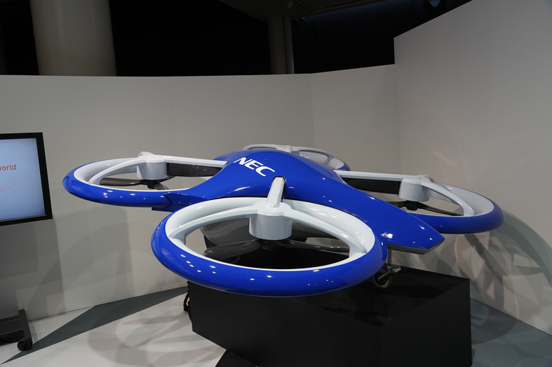 NECが展示した空飛ぶクルマの模型。空港と都市などを結ぶ交通システムになる。見た目はドローンのようだ