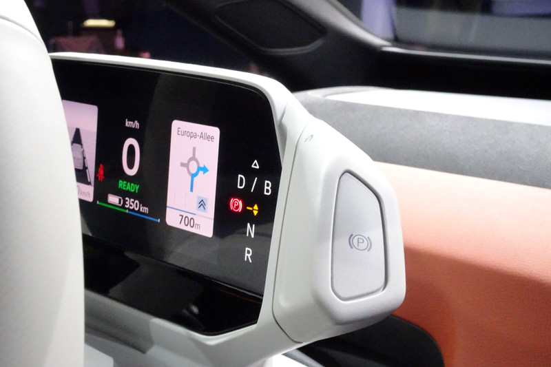 コクピットディスプレイはかなりコンパクトなもの。その横にパーキングブレーキのボタンが備わる