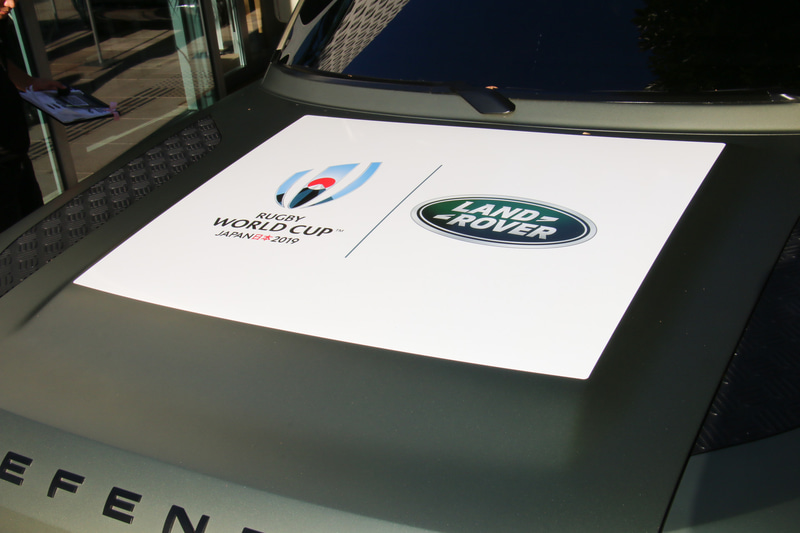 ボンネット上にラグビーワールドカップ 2019 日本大会とランドローバーのロゴが並ぶ