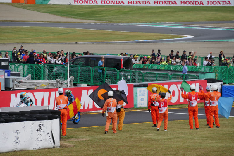 ピットに戻るレーサーを出迎えるマーシャルの皆さんをV6席から撮影。これが140mm（35mm換算で280mm）