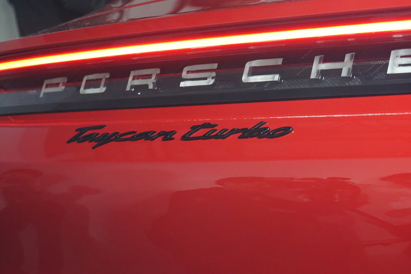 リアデザインのハイライトは、水平に伸びるガラス製ライトストリップとガラスルックのポルシェロゴ。タイカンの先進性に合わせたデザイン処理となっている