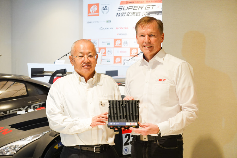メーダー氏が坂東代表にボッシュ製ECUを渡す