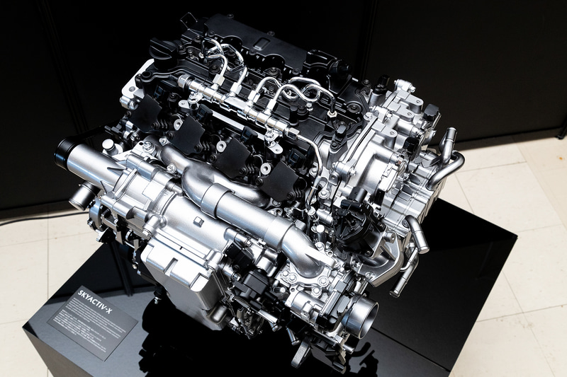 SKYACTIV-Xエンジンを上から見ると、ディーゼルエンジンのようなコモンレールとガソリンエンジンのようなイグニッションコイルが着いているのが見て取れる