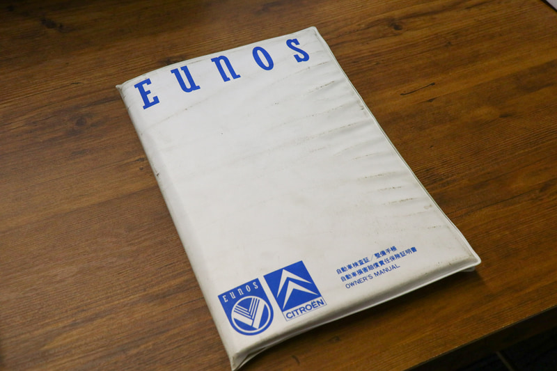 新車時からのオーナーの証。当時の販売店「ユーノス」の車検証入れ