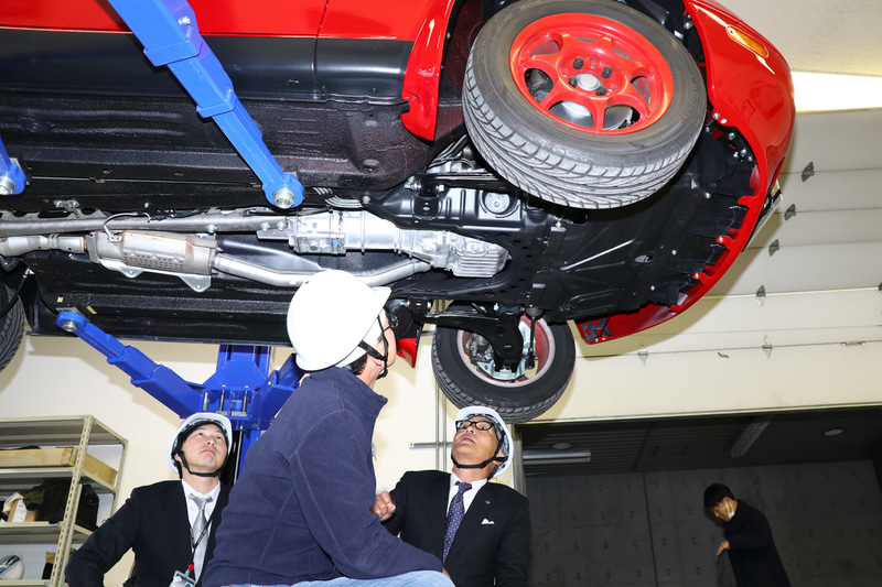 納車時にはオーナーが詳細説明を受ける。下まわりもレストア対象なのでリフトアップして説明を受ける