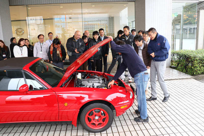マツダR＆Dセンター横浜の正面玄関まで移動すると、待ち構えていた社員がレストアしたロードスターに群がった