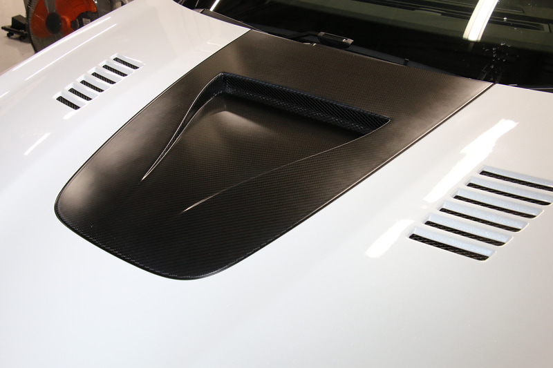 NACAダクトや排熱用のスリットなどを用意するカーボンボンネット。表側にはボディ同色塗装がしっかりと施されているが、裏側を見ると全面カーボンであることが分かる