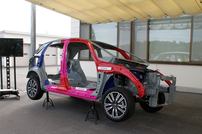 新型フィットのボディ。超高張力鋼板率（980MPa材以上）を従来モデルの10％から17％に引き上げるとともに、ボディ重量を4.5kg軽量化することに成功。ボディ剛性も3.4％向上したという。また、新型フィットでは心地よい視界を実現するため、従来とは異なる断面構造をAピラーに採用。万が一の衝突時にはボディに荷重を伝える構造として、十分な衝突安全性能とワイドで優れた視認性を両立させた