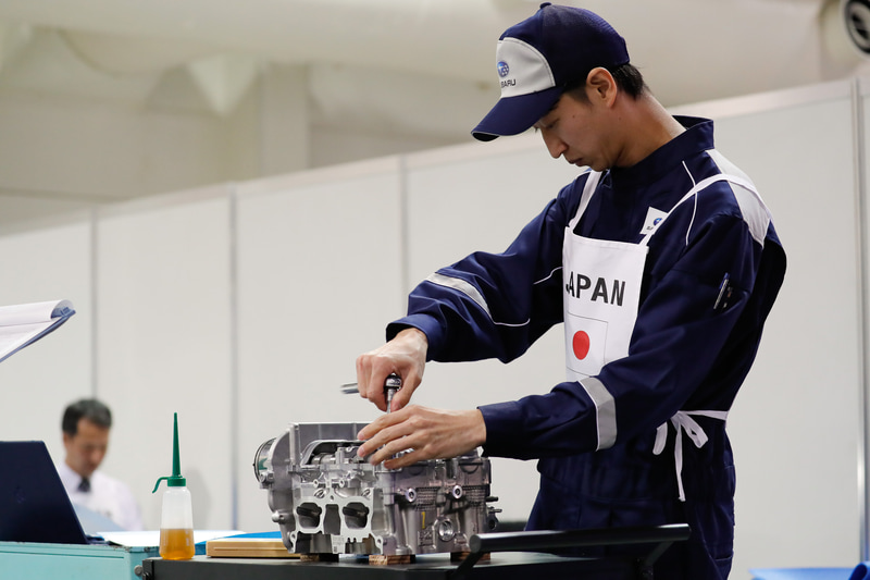 シリンダーヘッドの分解作業を行なう松本選手