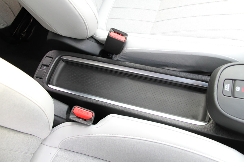 新型フィットのフロントシートは現行型の線で支えるSバネ構造から、面で支えるMAT構造に変更。柔らかな座り心地を持ちながら、乗員の体をしっかり保持する面支持構造によってロングドライブでの疲れにくさを実現したという。また、電動パーキングブレーキの標準装備化によってカバンや小物などを置くことが可能なテーブルコンソールを新採用している