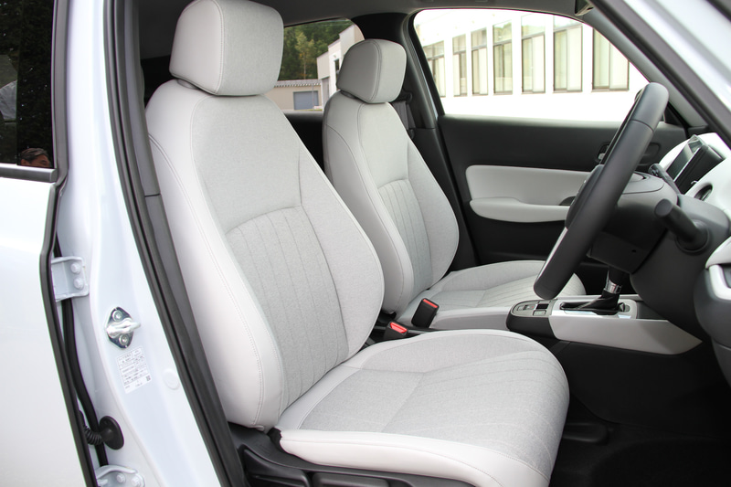 新型フィットのフロントシートは現行型の線で支えるSバネ構造から、面で支えるMAT構造に変更。柔らかな座り心地を持ちながら、乗員の体をしっかり保持する面支持構造によってロングドライブでの疲れにくさを実現したという。また、電動パーキングブレーキの標準装備化によってカバンや小物などを置くことが可能なテーブルコンソールを新採用している