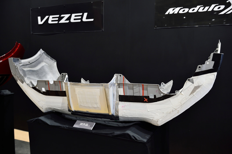 写真はフロントバンパーの試作品。中央部と両サイドで高さを変えることで、センターを軸に空気が流れるように開発。何度も脱着して最適な形状を探した