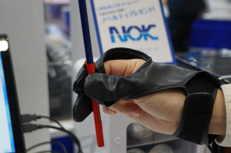 鉛筆を指先で転がしたり、缶ジュースの冷たさ、コップにビー玉を入れる振動など、センサーがついたグローブをはめた隣の人が行なうとその感覚が伝わってくる