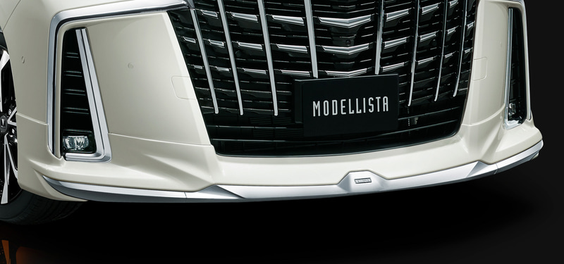 ボリューム感を持たせたシンプルな造形のスポイラー本体と、サイドに向かって勢いよく駆け上がる大型メッキ加飾とのコンビネーションによって、力強く煌びやかなフロントスタイリングを表現している