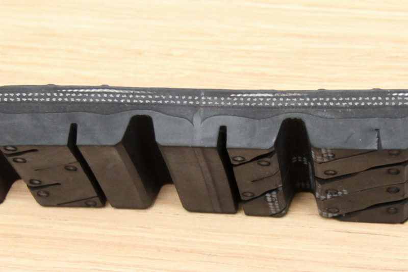 タイヤのカットモデル。中央部に縦に種類の異なるゴムが1本の線として通っている。この部分がアース