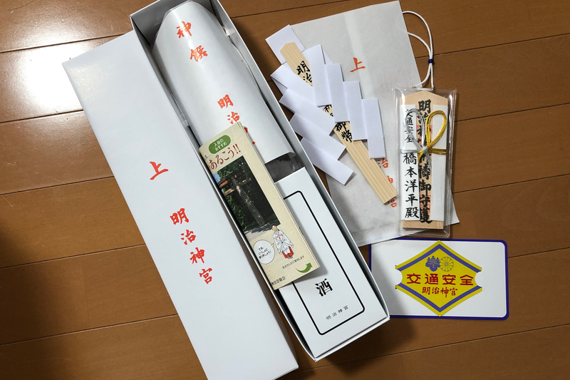 ご祈祷の後にいただいた手提げ袋には、こんなにたくさん入っていました。家の神棚におまつりする神札や御幣、車内に置くお守りから、車体に貼れる「交通安全」のステッカーまで。ようかんとお神酒も嬉しいですね。ちなみにクルマはらいの初穂料は5000円と1万円があり、これは1万円のものです