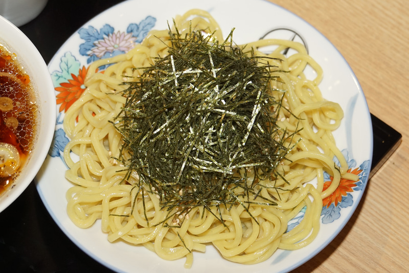 つけ麺タイプの肉そばのMinatoya 3 Vision“Mercedes-AMG GT Atatakai-Nikusoba”。メルセデス・ベンツが港屋とコラボして立ち食いそばをスタート!?。虎ノ門（現在は閉店）、大手町、そして3店舗目がメルセデスミー六本木に登場。メニューは1本勝負、その名もMinatoya 3 Vision“Mercedes-AMG GT Atatakai-Nikusoba”。AMG GT Rに続いてニュルブルクリンクのタイムを更新した新しいマシン名ではなく、創業者・菊地剛志さんがAMGソーラービーム（黄色）をまとったメルセデスAMG GTをイメージして作った肉そば。卵がついて価格は1200円