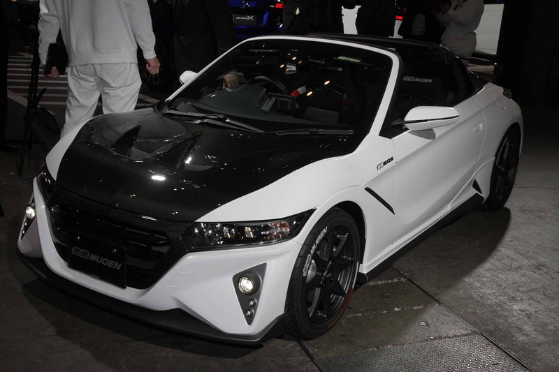 「MUGEN S660 Concept」は、フロントエアロバンパー、LEDフォグランプ、エアロイルミネーション、サイドスポイラー、リアエアロバンパー、カーボンフロントグリル、カーボンエアロボンネット、カーボンエンジンフード、カーボンリアウイング、スポーツサイレンサー（チタン製）、車高調整式スポーツサスペンション、カーボンナンバープレートガーニッシュ、パフォーマンスダンパーといった2020年夏発売予定のパーツを装着して参考出品