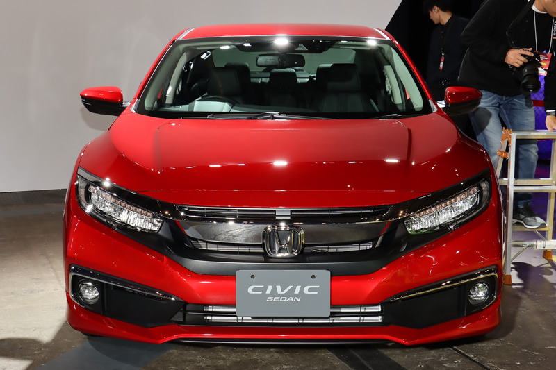 従来はセダン（左）とハッチバック（中央）で共通性の高いフロントマスクが与えられていたが、セダンのフロントバンパーをデザイン変更。バンパーのロアグリルが左右に連続するスタイルとなり、ワイド＆ローな雰囲気を演出している