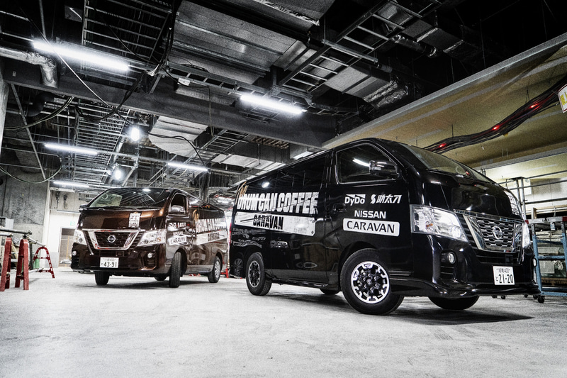 「助太刀アプリ」によって動員された「差し入れ人員」が建設現場へ差し入れを行なう。ファントムブラック（黒）の車両には「ドラム缶コーヒー ブラック」、インペリアルアンバー（茶）の車両には「ドラム缶コーヒー 微糖」を積載する