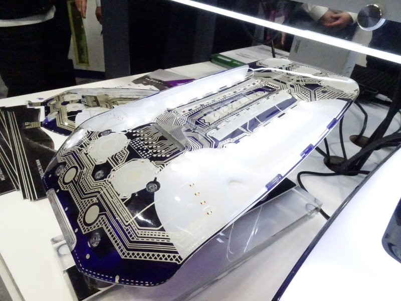 車内HMIで大切なタッチパネル。これはすでに実用化されているタッチパネルの内部（担当者の説明からBMW向けと推察）。タッチセンサー部分の薄型フィルム化によって、すでに木材を使ったタッチパネルも実用化されている