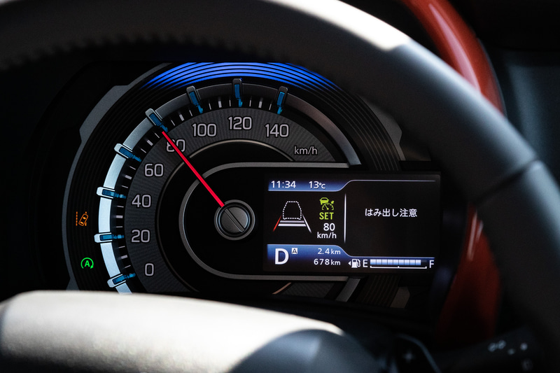 運転席メーターには「4.2インチカラー液晶メーター」をスズキ軽として初採用。立体的なリング形状とグラフィックでアウトドアアイテムの楽しさを表現したスピードメーターをはじめ、タコメーターや車速のデジタル表示、平均燃費/航続可能距離表示、ハイブリッドのエネルギーフロー表示、燃費履歴表示、ナビ表示や走行モードの表示などが可能