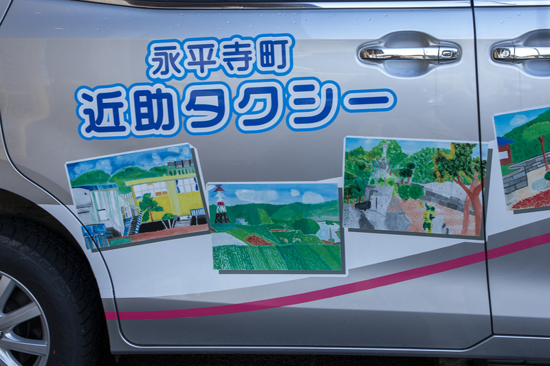 ボディ両サイドに描かれるイラストは、近助タクシーが運行する地区にある志比北小学校の子どもたちが描いたもの