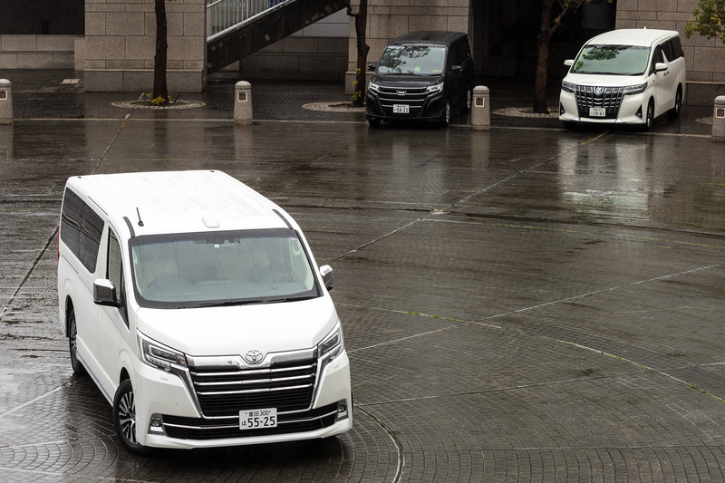 手前のグランエースの奥に見えるのは、同じミニバンシリーズの「ノア」（左）と「アルファード」（右）。ノアがコンパクトミニバンに、アルファードがよくあるミニバンサイズのように見えるのは、遠近法の効果だけではない