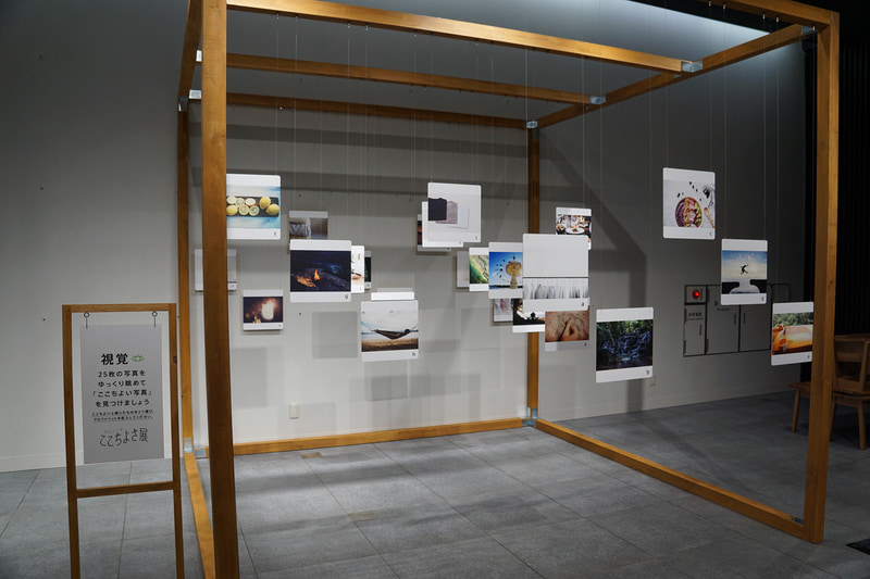 視覚ブース「ここちよい写真」。選択肢は「星空とテント」「海辺のハンモック」など25種類。ホンダの「人研究」でも行なった写真選択による感性価値研究。その体感版としてシーンや構図が異なる25枚の写真を掲出。じっくりと見て、ここちよい写真を選択する