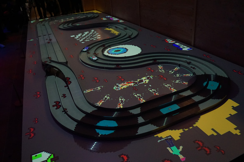 高速で走行するミニ四駆のボディカラーはプロジェクションマッピングを施して再現している