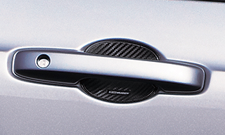 ドアハンドルプロテクター（単体価格：3080円）は、ドア開閉時に爪などによる傷を防止できるだけでなく、カーボン調のシボ加工を施すことでドアハンドルまわりをスポーティに演出