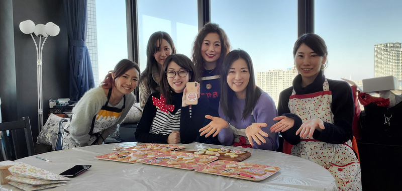 バレンタインに向けた、クルマ好きのためのアイシングクッキー教室に集った5名の生徒とあゆみ先生（左端）でパチリ。後列左は光文社「HERS」でライターをされている北川真紀子さん、後列右はトヨタ自動車の山田貴子さん、前列右は私のクルマ遊び仲間・田村あさよさん。実は先生も含め、全員がクルマ業界女子部のメンバーなんです。なので今度は、由美さんが持っているスマホに貼ってある、女子部の安全運転啓蒙活動「＃置きシュー」のロゴマークのクッキーを作りたいね、と盛り上がりました