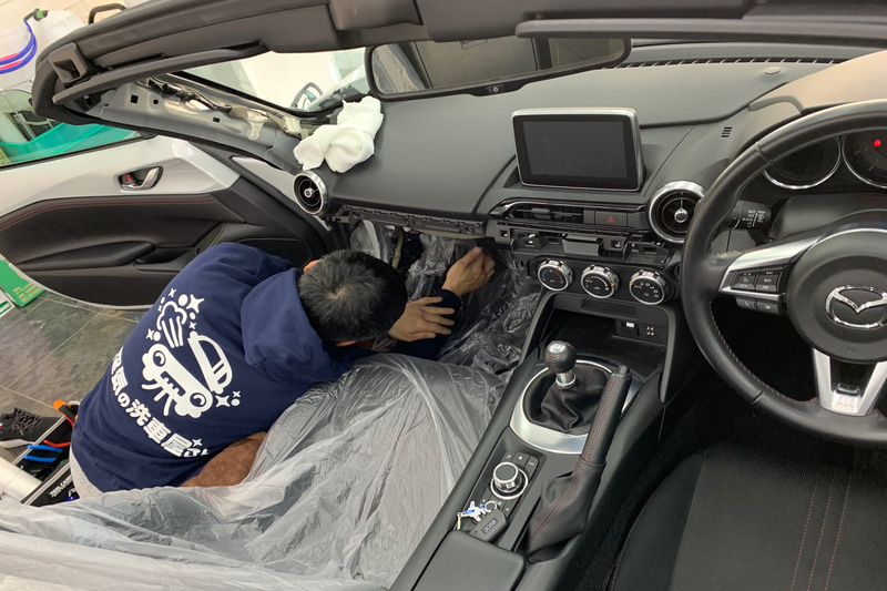 シートにカバーをかけてエアコン清掃の作業に入る