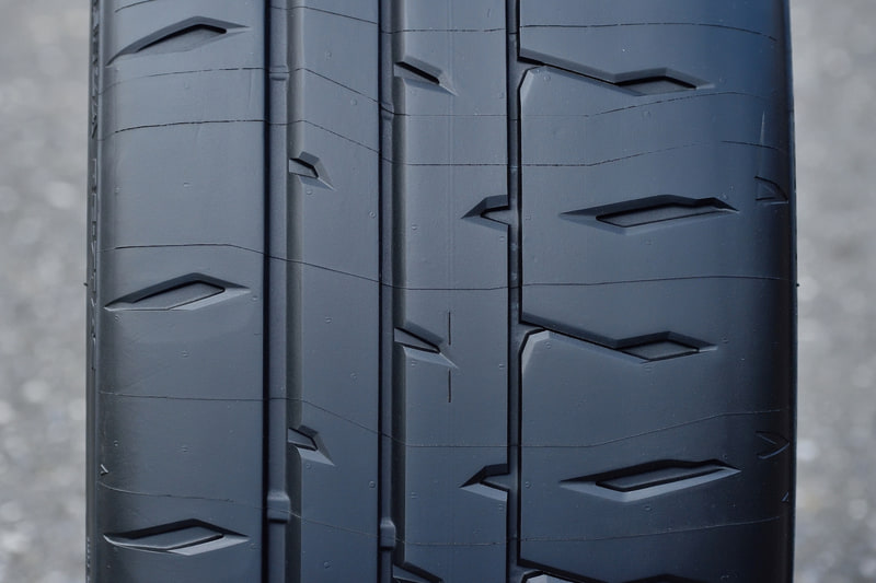 向かって左がIN側、右がOUT側。RE-71RS向けに最適化した非対称パターンや非対称形状を採用し、ドライ路面でのグリップ力とコントロール性を高次元で両立。ロングライフ性能も特徴とする