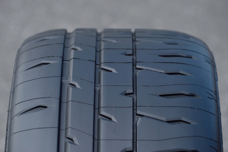 向かって左がIN側、右がOUT側。RE-71RS向けに最適化した非対称パターンや非対称形状を採用し、ドライ路面でのグリップ力とコントロール性を高次元で両立。ロングライフ性能も特徴とする