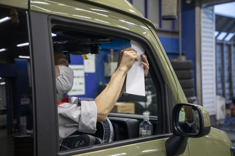 2つ折りにしたコピー用紙をシックネスゲージ替わりに使い、ドアを閉めた状態でのウェザーストリップの当たり具合をチェック