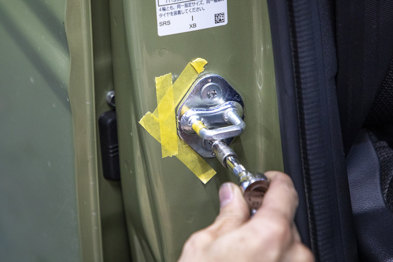 ストライカーを動かしてドアの位置を微調整。マスキングテープで元の位置をマーキングしてから取り付けネジを緩める