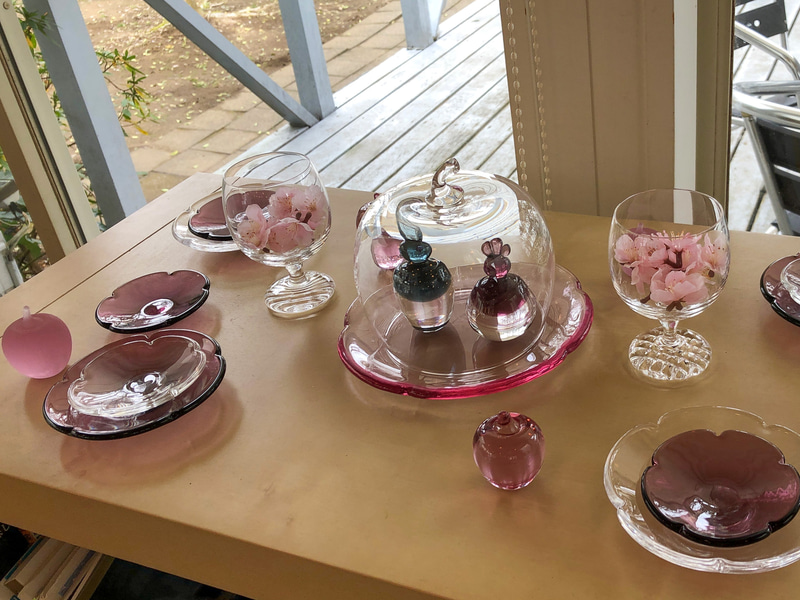 カフェの店内にディスプレイしてあった、ガラスのおひなさまとおもてなしのテーブルコーディネート。お花の大小のガラスプレートを2色重ねたり、グラスの中に花びらを入れるなど、真似したいなぁと思うとっても素敵なディスプレイでした。こちらの器たちも、すべて隣りのギャラリーで購入できますよ
