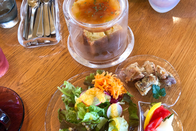 これが私がオーダーしたランチメニュー、「本日のケークサレ」です。3つに分かれたガラスプレートも素敵なのですが、スープの入った器をよけると、メインのケークサレが登場するという、驚きの器たち。カトラリーケースもガラスだったり、存分にガラスの魅力が楽しめます
