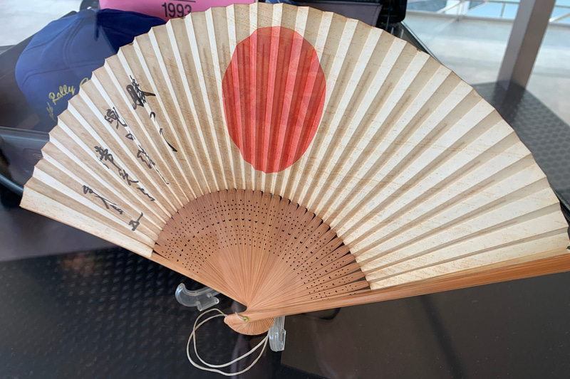 STI育ての親、久世隆一郎さんの扇子。「勝って兜の緒を締めよ」と記してある