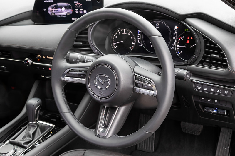 インテリアでは形状を単純化するとともに、装飾やパーティングラインを減らすなど、シンプルな水平基調と要素をそぎ落とした造形によって美しさ、上質感、運転に集中できる心地よい空間を表現。撮影車はブラック・レザー内装で、本革についてはマツダのデザイナーと革職人が共同で新開発した内装シボを採用。部位によってさまざまなパターンを持たせることで、本物ならではの不均一さを再現したという