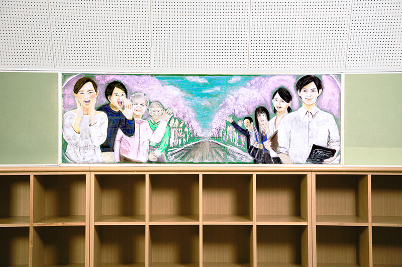 後ろの黒板にはリアウィンドウから見えるこれまで走ってきた道を表現