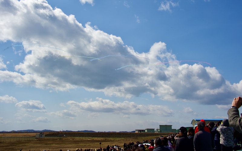 ブルーインパルスがスモークで描く五輪の輪は、強風に吹きとばされてしまった。残念