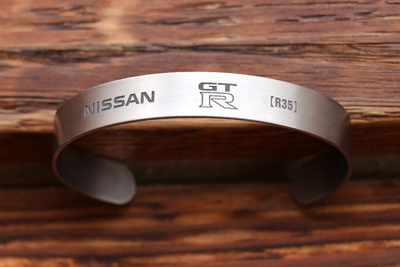 ボディはチタン特有の灰色がかったシルバーで、表面に各GT-Rのエンブレムや型番などを刻印