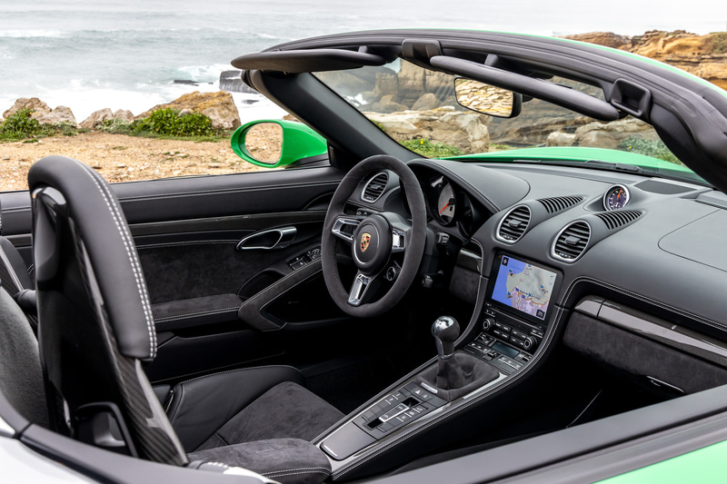 インテリアでは、標準装備のスポーツシートプラスのセンターパネル、ステアリングホイールリム、センターコンソール、シフトレバーおよび両側ドアのアームレストに、ダークカラーのアルカンターラを採用。スポーティでエレガントな雰囲気を演出。高解像度7インチタッチスクリーンを備えたポルシェコミュニケーションマネジメント（PCM）と拡張されたトラックプレシジョンアプリを含むスポーツクロノパッケージを標準装備する
