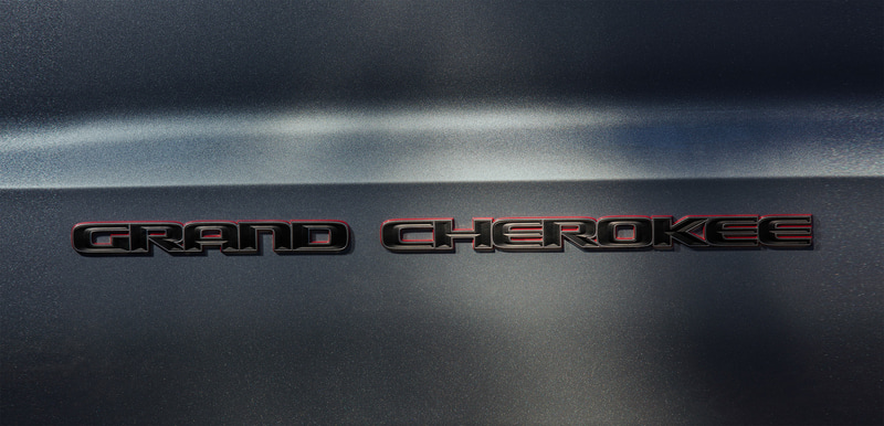 レッドのアクセントカラーをあしらったナチュラルグレーの「Jeep」バッヂや「Grand Cherokee」バッヂ