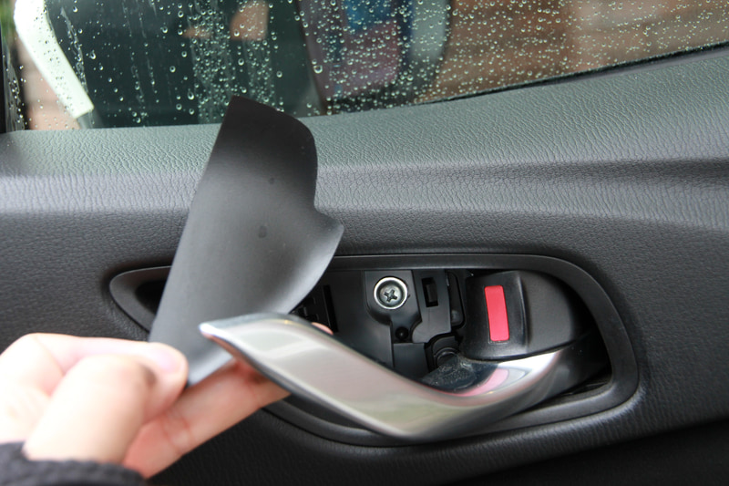 ドアの内張りはネジ止めされています。1箇所がこのオープナーのところ。内側のカバーをコジって外すとネジが見えます